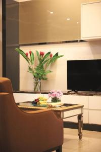a living room with a table and a tv at Dorsett Kuala Lumpur in Kuala Lumpur