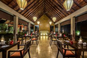 un restaurante con mesas de madera, sillas y luces en Roo Mansala Boutique Villas en Sigiriya