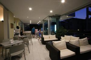 un restaurante con sofás, mesas y gente caminando en Hotel Roby, en Lido di Jesolo