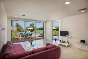 Blue Sea Luxury Villa في ماليم: غرفة معيشة مع أريكة حمراء وتلفزيون