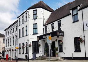 um grande edifício branco numa rua da cidade em The Castle Hotel Neath em Neath