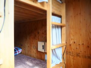 a bunk bed in a wooden cabin with a window at EkimaehouseSamaru in Shimanto-cho