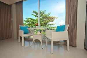 a dining room with a table and chairs and a window at Chalong Beach Front Residence in Rawai Beach