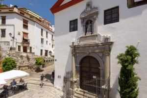ein weißes Gebäude mit einem Tor und einer Statue über einer Tür in der Unterkunft Apartamento en pleno centro, WIFI, ideal in Granada
