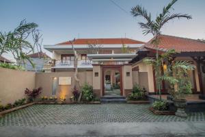 a house with a courtyard in front of it at Anindya Homestay in Sanur