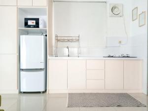 a kitchen with white cabinets and a refrigerator at Vaincation at Ritze Perdana 2 Damansara Perdana in Petaling Jaya