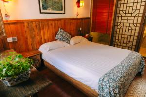 a bedroom with a bed and a potted plant at September Hui zhou Homestay in She
