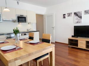 uma cozinha e sala de jantar com uma mesa e uma televisão em Appartement Jana by Schladming-Appartements em Schladming