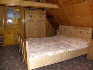 a large bed in a room with a wooden ceiling at Chalupa u lesa in Červená Voda