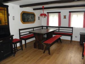 a dining room with a wooden table and benches at Chalupa u lesa in Červená Voda +28 photos