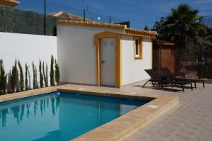 a small house with a swimming pool next to a building at Villa Ensueño with private pool and large garden in Mazarrón