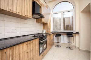 a kitchen with wooden cabinets and black counter tops at Stay Inn Apartments at Mashtots Avenue 5A in Yerevan