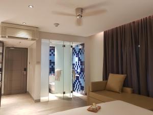 a living room with a couch and a glass wall at Lagùn Hotel in El Nido