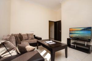 a living room with a couch and a flat screen tv at Stay Inn Apartments at Mashtots Avenue 5A in Yerevan