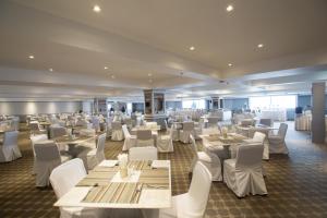 a dining room with white tables and white chairs at The Pantip Hotel Ladprao Bangkok in Bangkok
