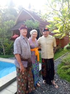 un groupe de trois personnes debout à côté d'une piscine dans l'établissement Halumba Eco Villa Bali, à Tejakula