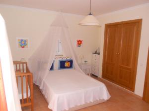 a bedroom with a bed with a mosquito net at Algarve Praia Verde in Altura