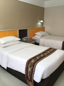 Postel nebo postele na pokoji v ubytování Tonkoon Hotel