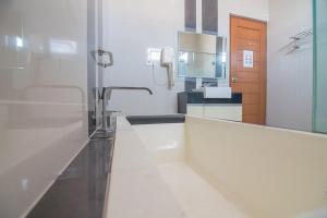 a white bathroom with a sink and a mirror at RedDoorz near Jatinangor Town Square in Jatinangor +31 photos