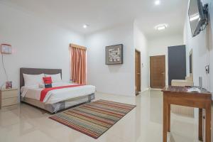 a bedroom with a bed and a desk in it at RedDoorz near Jatinangor Town Square in Jatinangor