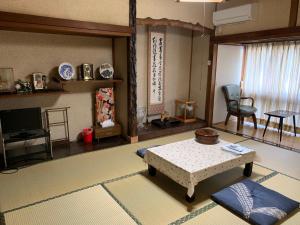 een woonkamer met een tafel en een televisie bij Hoshi Ryokan in Tsuwano