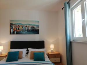 1 dormitorio con 1 cama y una pintura en la pared en Guesthouse Oliva, en Cavtat