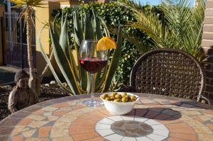 a glass of wine and a bowl of fruit on a table at Villa Ensueño with private pool and large garden in Mazarrón