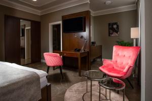 um quarto de hotel com uma cama, uma secretária e cadeiras em Hotel Anna em Beroun