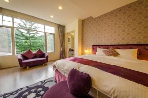 a bedroom with a large bed and a chair at Butchard Villas in Yuchi +108 photos