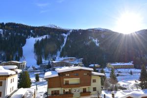a town in the snow with a mountain at EMERALD CENTRALE in Madonna di Campiglio