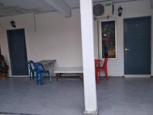 een tafel en stoelen in een kamer met blauwe deuren bij Niyaz Inn in Pantai Cenang