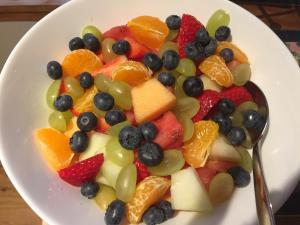 a bowl of fruit on a plate with a spoon at Applegrove B&B in Boat of Garten +26 photos