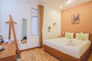 a bedroom with a bed and a desk and a window at Jessy's Green House Da Lat in Da Lat