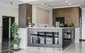 a lobby with a counter with plants in it at Hotel Amfora in Vyazma