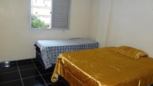 Zimmer mit 2 Betten und einem Fenster in der Unterkunft Apartamento Guaruja Bacaitava in Guarujá
