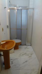 ein Bad mit einer Dusche, einem WC und einem Waschbecken in der Unterkunft Apartamento Guaruja Bacaitava in Guarujá