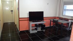 ein Wohnzimmer mit einem Flachbild-TV auf einem Tisch in der Unterkunft Apartamento Guaruja Bacaitava in Guarujá