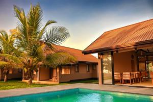 a house with a swimming pool in front of a house at Melheim Beach Kalpitiya in Kalpitiya