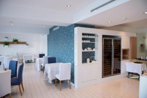 a dining room with white tables and blue chairs at Hotel Miramare Stabia in Castellammare di Stabia