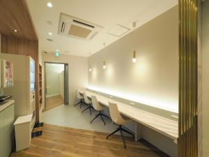 una sala de conferencias con una mesa larga y sillas en Leo Yu Capsule Hotel Funabashi en Funabashi