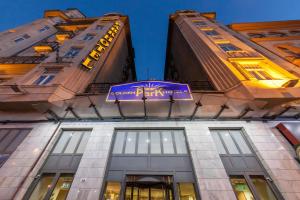 un edificio con un cartello viola sul lato. di Hotel Golden Park Budapest a Budapest