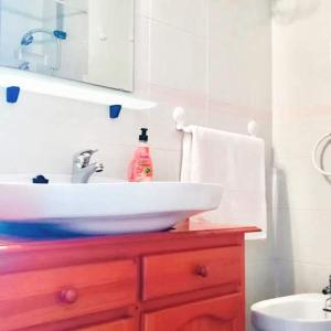 baño con lavabo blanco y armario de madera roja en Appartement vue mer et soleil toute l année, en Costa de Antigua