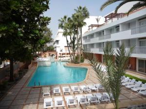 HOTEL KAMAL CITY CENTER في أغادير: اطلالة جوية على مسبح الفندق مع كراسي الصالة