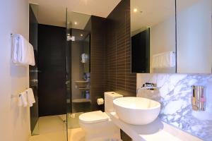 a bathroom with a sink and a toilet and a shower at Flinders Street Apartments in Melbourne