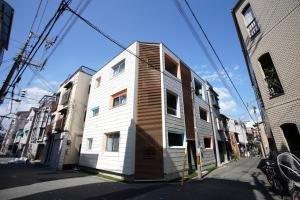 a white building on the side of a street at Koti Sopo Universal Bay 1 by Liaison in Osaka