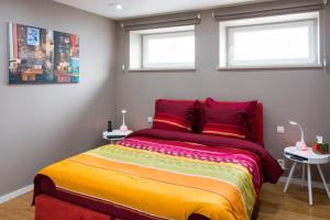 - une chambre avec un lit coloré et 2 fenêtres dans l'établissement Iddup Atrium, à Oreye