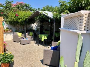 un patio con mesa, sillas y plantas en B&B Vento del Mare, en San Pietro in Bevagna