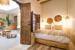 sypialnia z łóżkiem i otwartymi drzwiami w obiekcie Medina Sun w Marakeszu