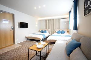 a hotel room with two beds and a couch at Koti Sopo Universal Bay 1 by Liaison in Osaka