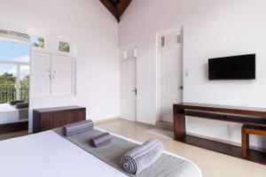 a living room with a bed and a piano at Subaseth Villa in Anuradhapura